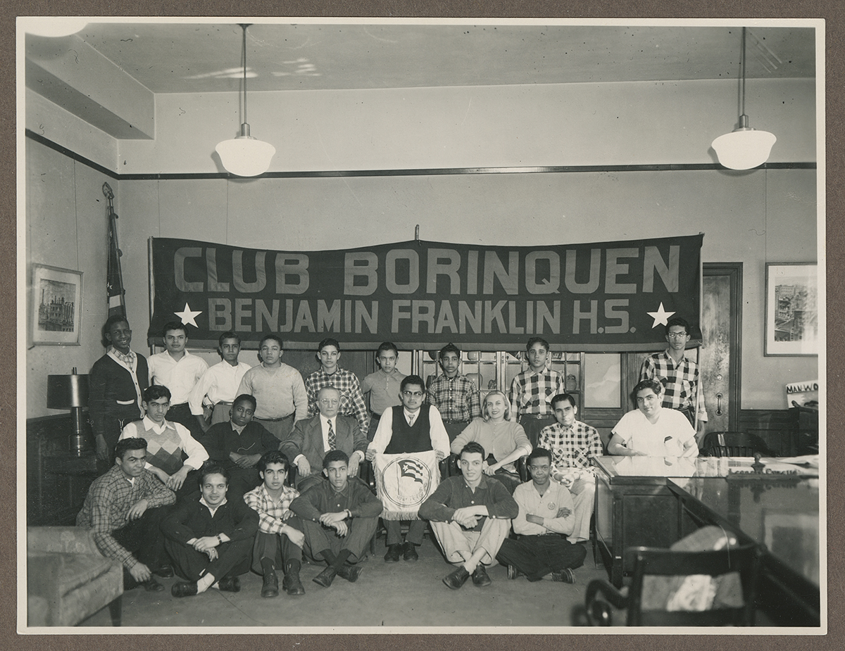Students lined up for a group photo in front of a "Club Borinquen Benjamin Franklin H.S." banner