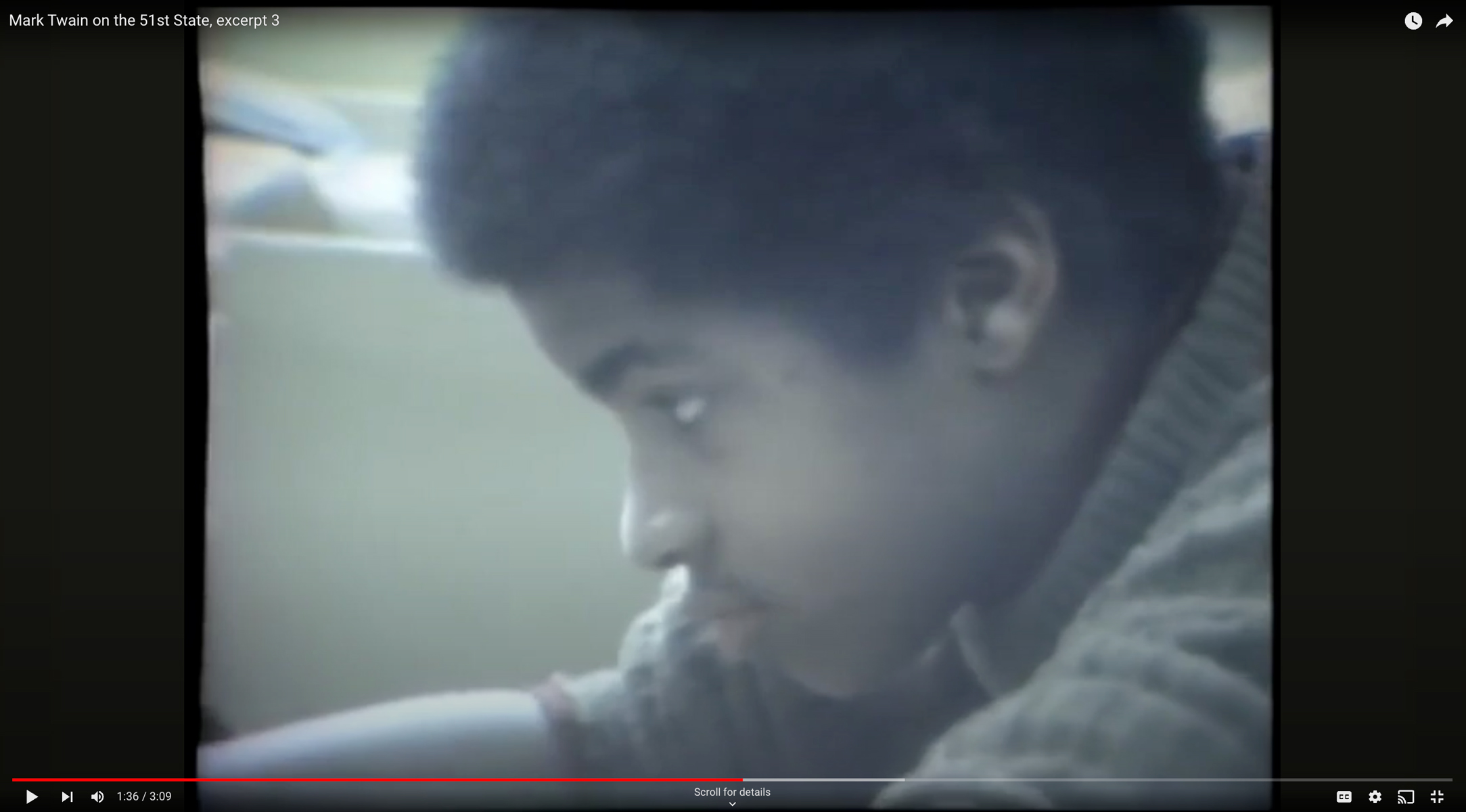 Still image from a news report showing a young black boy in a classroom doing school work