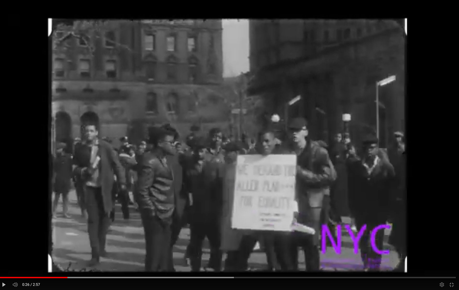 Protestors march, carrying signs