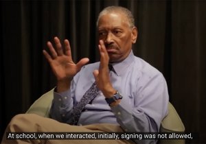 Still image from video interview with Thomas Samuels, an older Black man, who signs.