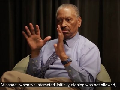 Still image from video interview with Thomas Samuels, an older Black man, who signs.